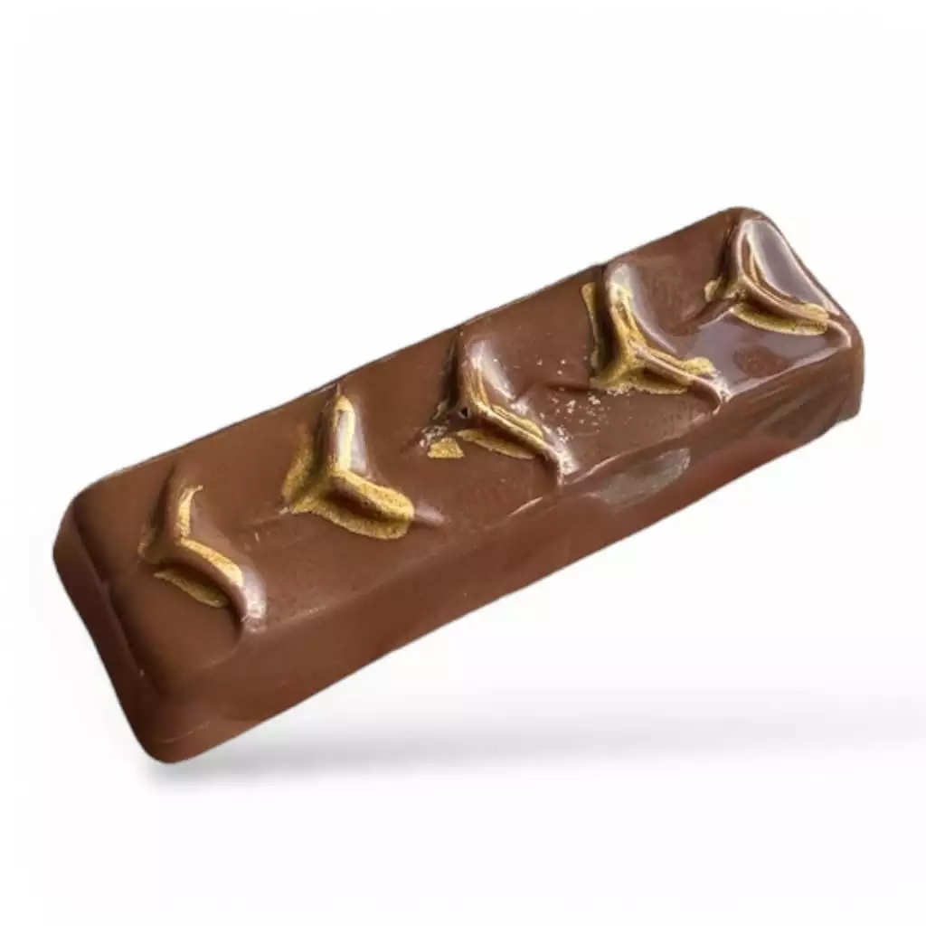 Ladymums – en chokladbit med mördeg och kola En Ladymums-chokladbit i mjölkchoklad med en dekorativ yta och gulddetaljer.