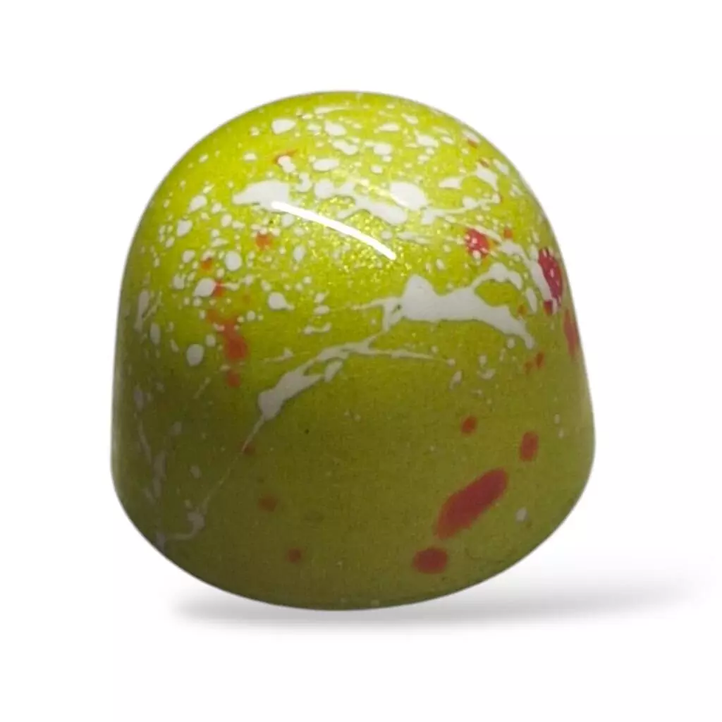 Pralinen Prinsesstårta – en klassiker i chokladform Grön och vit stänkmålad pralin med rosa inslag, fylld med smaker inspirerade av prinsesstårta.