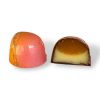 En Solkyss-pralin delad på mitten, som visar fyllningen av mango-pâte de fruit och vit chokladganache.