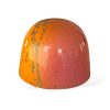 En närbild på en Solkyss-pralin med ett glansigt, marmorerat skal i orange och rosa nyanser.